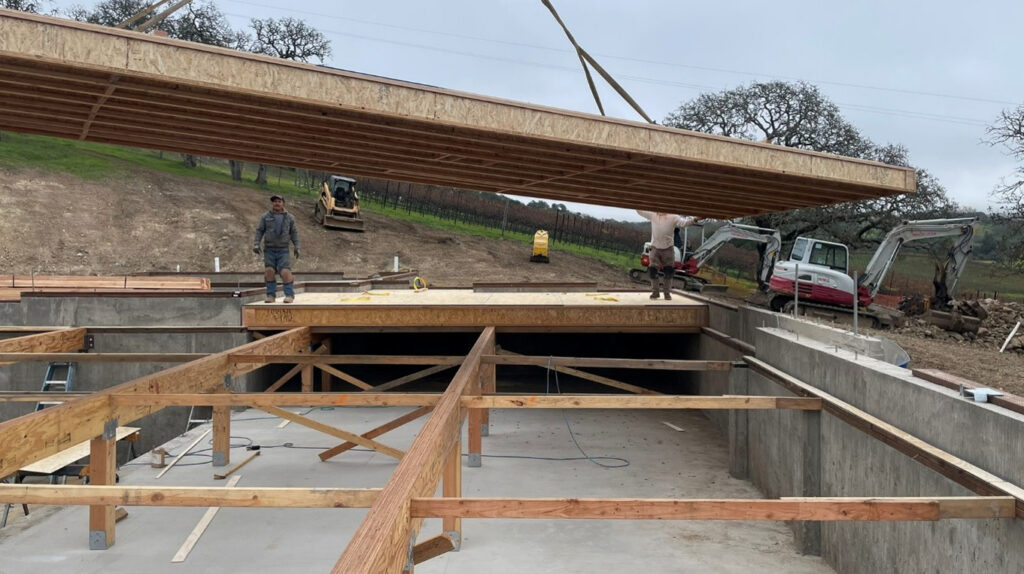 A crane lifts a panel at a building site in Napa