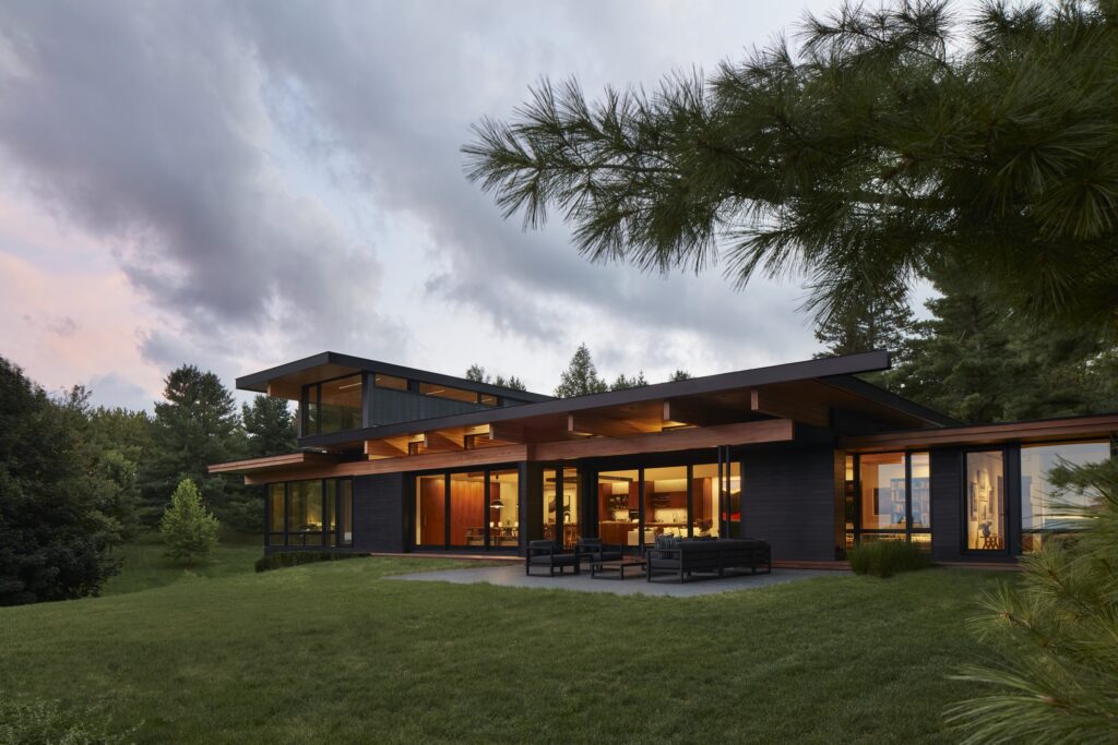 Rear exterior view of a modern home lit from within