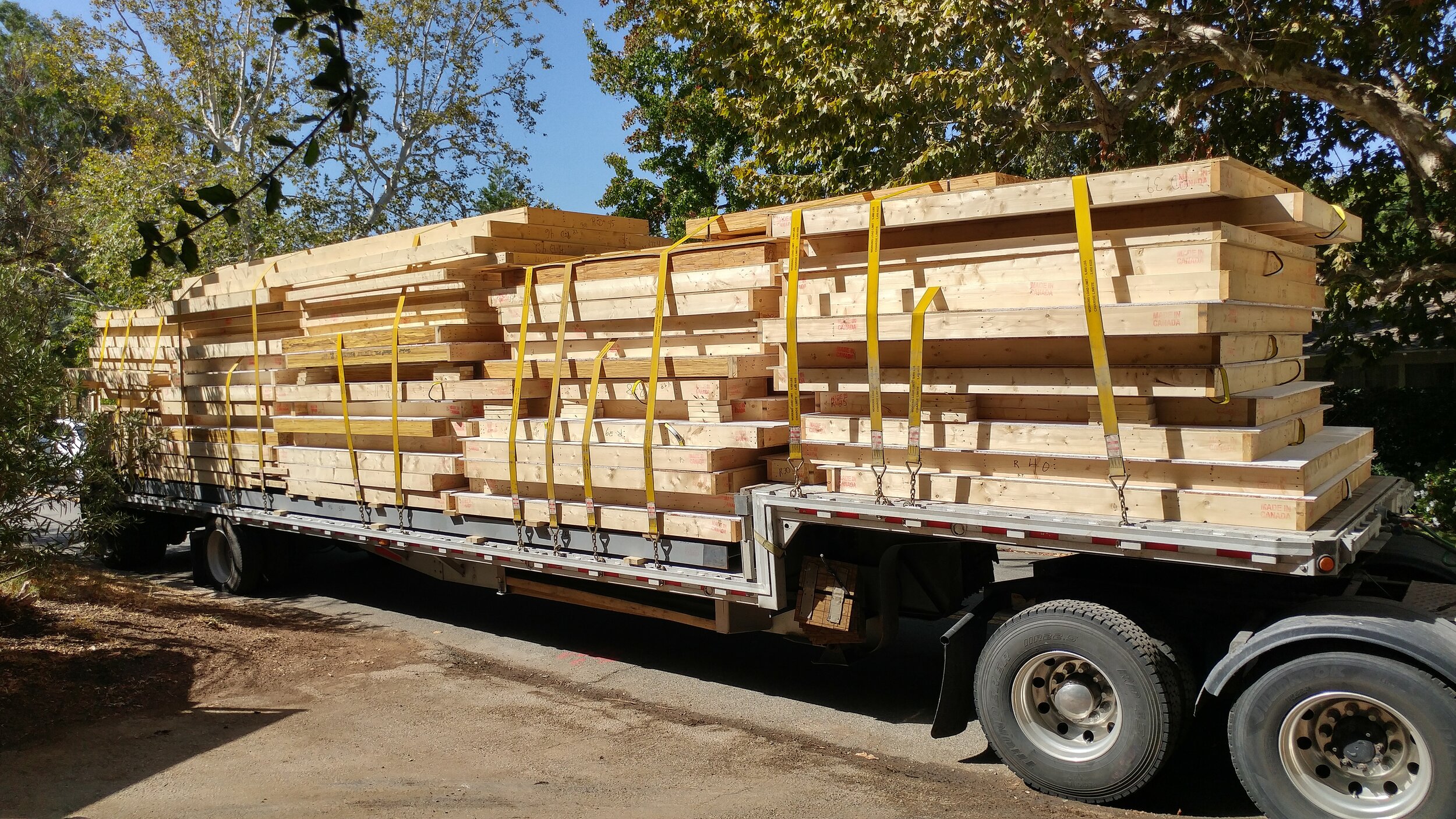 Componentes de construcción de madera embalados y asegurados en un camión de plataforma