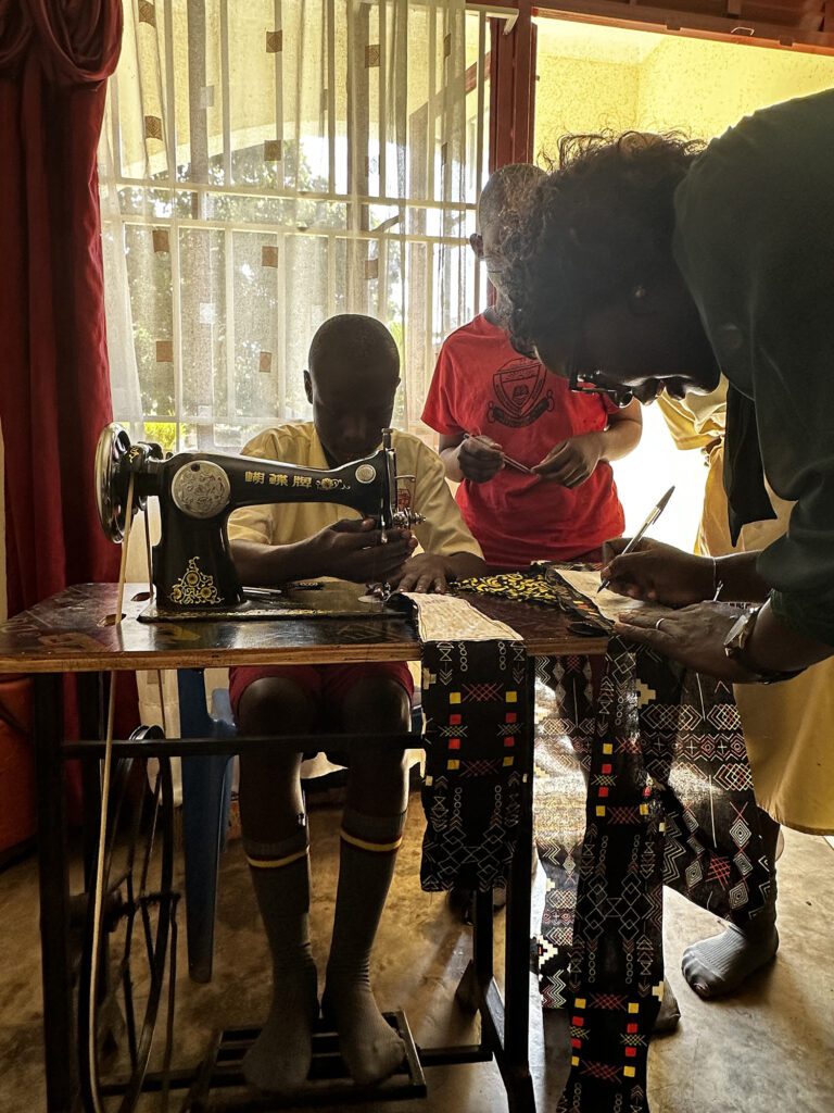 A MoonCatcher Project staff member teaches children how to use a sewing machine. 