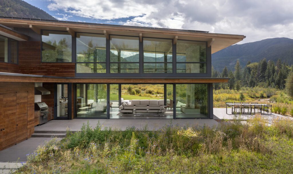 View through a modern mountain home with glass walls on both sides