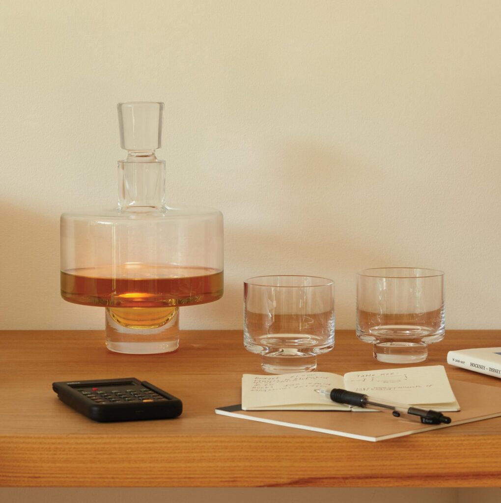 Glass whiskey decanter with glass and a notepad