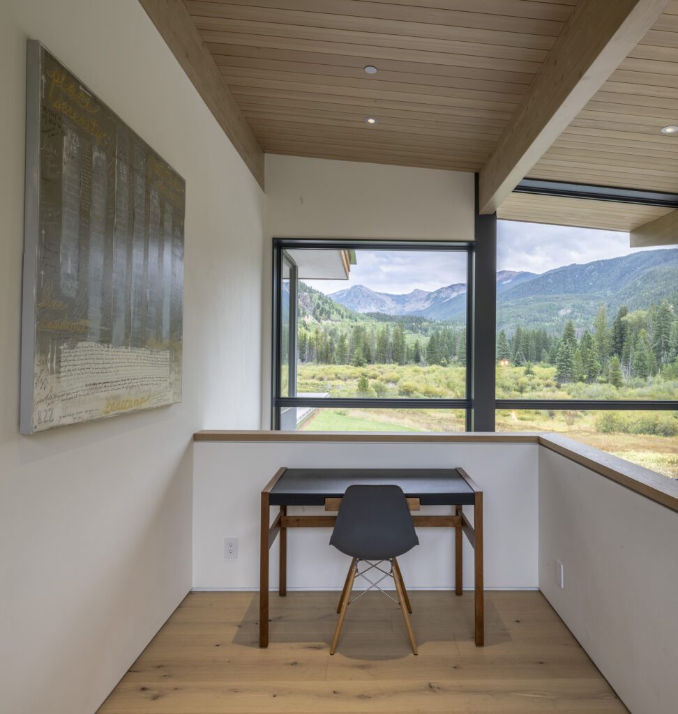 Loft office with a view of the mountains and forest beyond