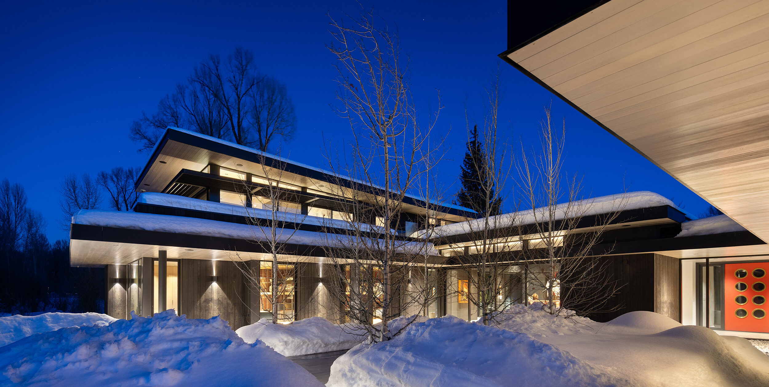 Close exterior view of a modern home at dawn in the snow