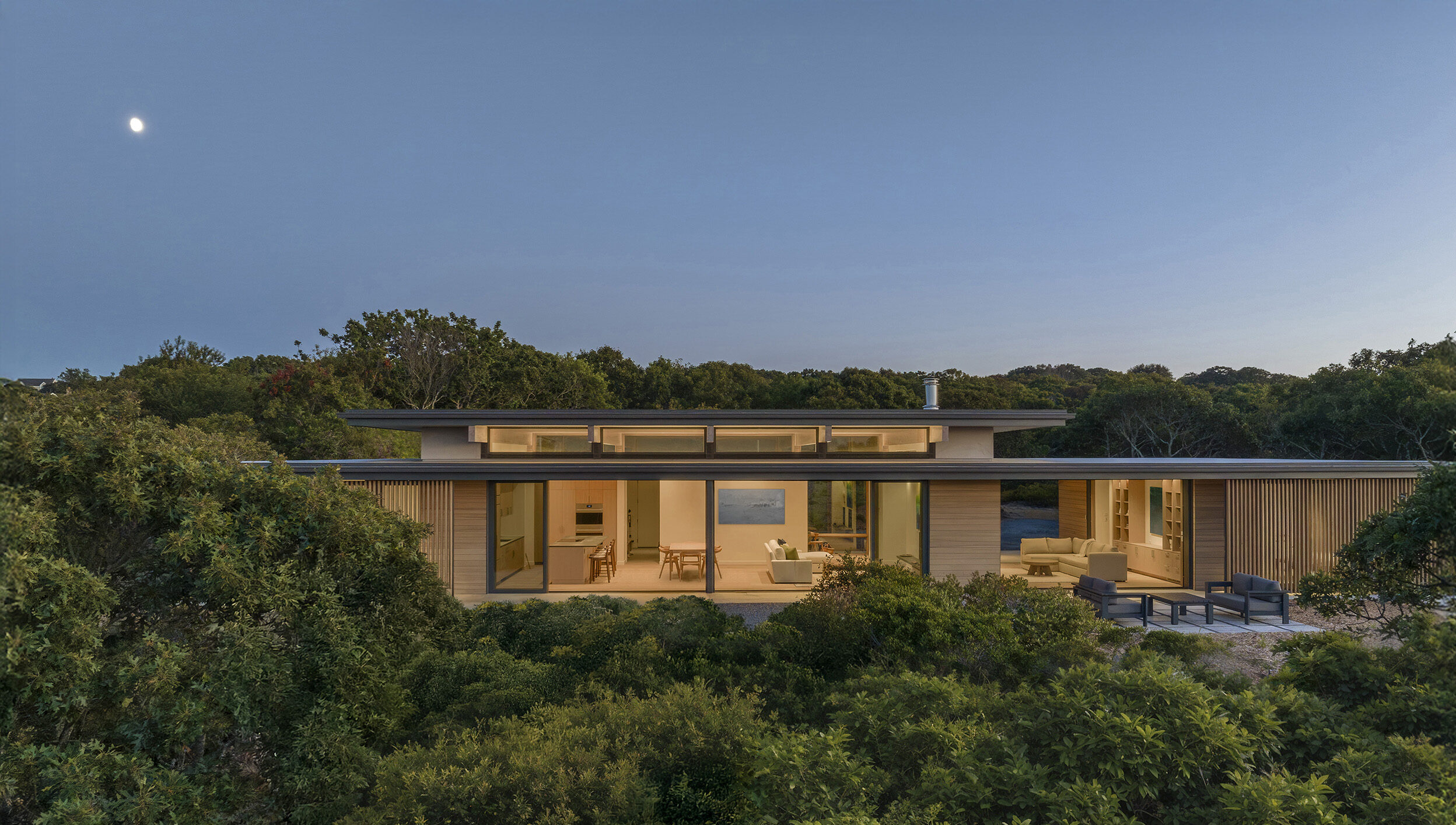 Single-level modern home perched on a bluff at twilight